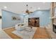 Cozy living room with light blue walls, hardwood floors, a fireplace, and a ceiling fan at 1007 Morfield Ln, Brandon, FL 33511