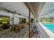 Covered patio area with ceiling fans, dining table and furniture overlooking the screened in pool at 1007 Morfield Ln, Brandon, FL 33511
