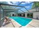 Screened-in pool area with lounge chairs and clear blue water, perfect for relaxing and entertaining at 1007 Morfield Ln, Brandon, FL 33511