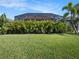 A well-maintained backyard showcasing a screened-in lanai and manicured lawn at 10450 Highland Park Pl, Palmetto, FL 34221