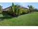 Expansive lawn with lush landscaping, highlighting the home's screened patio at 10450 Highland Park Pl, Palmetto, FL 34221