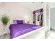 A stylish bedroom boasts a white bed frame, patterned wallpaper, and a closet with ample storage space at 10450 Highland Park Pl, Palmetto, FL 34221