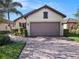 Charming home featuring a two-car garage, brick-paved driveway, and well-maintained landscaping at 10450 Highland Park Pl, Palmetto, FL 34221