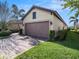 Home featuring a two-car garage, landscaped front yard, and a brick-paved driveway at 10450 Highland Park Pl, Palmetto, FL 34221
