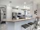 Well-lit kitchen featuring a breakfast bar, stainless steel appliances, and stylish pendant lighting at 10450 Highland Park Pl, Palmetto, FL 34221