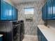 Well-equipped laundry room with blue cabinets, modern appliances, and a window for natural light at 10450 Highland Park Pl, Palmetto, FL 34221
