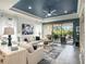 Elegant living room features stylish furnishings, blue accents, and a sliding glass door to screened lanai at 10450 Highland Park Pl, Palmetto, FL 34221
