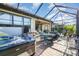 Spacious enclosed patio features a hot tub, ample seating, a dining area, and a cozy fire table at 10450 Highland Park Pl, Palmetto, FL 34221