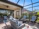 Screened-in patio features comfortable seating, a fire table, and stylish decor, perfect for outdoor living at 10450 Highland Park Pl, Palmetto, FL 34221