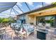 Beautiful enclosed patio with a hot tub, comfortable seating areas, a fire table, and outdoor dining space at 10450 Highland Park Pl, Palmetto, FL 34221