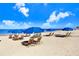 Relaxing beach scene featuring lounge chairs under large umbrellas on a sunny day at 1134 Starfish Ln, Tarpon Springs, FL 34689