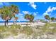Beach scene with palm trees and view of a beach with clear skies in the distance at 1134 Starfish Ln, Tarpon Springs, FL 34689