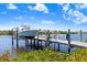 Private boat dock featuring a lift and ample space for docking boats on a sunny day at 1134 Starfish Ln, Tarpon Springs, FL 34689