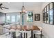 Bright dining area with rustic table and modern chairs, with access to the living area and outdoor balcony at 1134 Starfish Ln, Tarpon Springs, FL 34689
