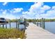 A wooden dock with boat lift surrounded by lush greenery, calm waters, and a sunny sky at 1134 Starfish Ln, Tarpon Springs, FL 34689