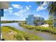A waterfront view of charming blue townhomes with lush green landscaping and boat docks on a sunny day at 1134 Starfish Ln, Tarpon Springs, FL 34689