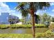 A waterfront view of charming blue townhomes with lush green landscaping on a sunny day at 1134 Starfish Ln, Tarpon Springs, FL 34689