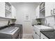 Well-organized laundry room features a farmhouse sink, ample cabinet space, and modern washer and dryer at 1134 Starfish Ln, Tarpon Springs, FL 34689