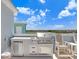 Well-equipped outdoor kitchen with a built-in grill, refrigerator, and counter space, perfect for outdoor cooking at 1134 Starfish Ln, Tarpon Springs, FL 34689