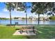 Picturesque waterfront view with a picnic table, bench, and serene water, perfect for relaxation and enjoying the outdoors at 1134 Starfish Ln, Tarpon Springs, FL 34689