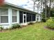 Exterior shot of the house with screened in porch, showing the well maintained landscaping and lawn at 11752 Wayside Willow Ct, Hudson, FL 34667