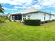 Rear view of a well-maintained home with a green lawn and manicured landscaping at 11752 Wayside Willow Ct, Hudson, FL 34667
