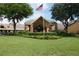 Exterior shot of community clubhouse surrounded by green grass and professional landscaping at 11752 Wayside Willow Ct, Hudson, FL 34667