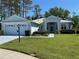 Charming light blue single-story home featuring a well-manicured lawn and neatly trimmed shrubbery at 11752 Wayside Willow Ct, Hudson, FL 34667