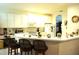Bright kitchen area with white cabinets, tiled floors, and bar seating at 11752 Wayside Willow Ct, Hudson, FL 34667
