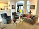 Cozy living room with comfortable seating, a glass coffee table, and views into the kitchen and dining area at 11752 Wayside Willow Ct, Hudson, FL 34667