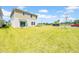 Backyard featuring a patio with chairs, large grassy area, and exterior view of the home at 12908 Hawkstone Trail Blvd, Lithia, FL 33547