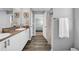 Bathroom with dual sinks, granite countertops, wood-look floors, and decorative coastal accents at 12908 Hawkstone Trail Blvd, Lithia, FL 33547