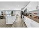 Bright kitchen boasts white cabinets, stainless steel appliances, and an island, seamlessly flowing into the living area at 12908 Hawkstone Trail Blvd, Lithia, FL 33547
