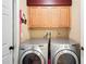 Convenient laundry room featuring upper cabinets, full-size washer and dryer units and extra storage space at 12918 Royal George Ave, Odessa, FL 33556