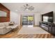 Cozy living room with hardwood floors, modern fan, and sliding doors to a backyard view at 12918 Royal George Ave, Odessa, FL 33556