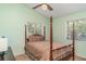 Cozy bedroom with a four-poster bed, neutral color scheme, and ample natural light at 1305 Greenfield Cir, Venice, FL 34292