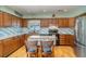 Well-equipped kitchen with stainless steel appliances, wood cabinets, and tile backsplash at 1305 Greenfield Cir, Venice, FL 34292