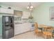 Functional kitchen with white cabinets, appliances, and a breakfast nook at 1305 Greenfield Cir, Venice, FL 34292