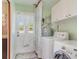 Laundry room features modern washer and dryer, utility sink, and storage at 1305 Greenfield Cir, Venice, FL 34292