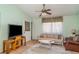 Cozy living room featuring a ceiling fan, sofa, and large windows at 1305 Greenfield Cir, Venice, FL 34292