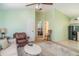 Spacious living room with light green walls, ceiling fan, and bedroom doorway at 1305 Greenfield Cir, Venice, FL 34292