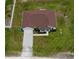 Aerial view of house featuring a brown roof, paved driveway, surrounding yard, and green landscaping at 13486 English Sparrow Rd, Weeki Wachee, FL 34614