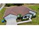 Aerial view of house with a driveway, two-car garage, covered entryway, and surrounding green lawn at 13486 English Sparrow Rd, Weeki Wachee, FL 34614