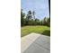 View of the spacious backyard with plenty of green space and a concrete patio at 13486 English Sparrow Rd, Weeki Wachee, FL 34614