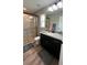 Well-lit bathroom with a granite countertop vanity, black fixtures, and a glass-enclosed shower at 13486 English Sparrow Rd, Weeki Wachee, FL 34614