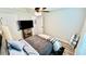 Cozy bedroom featuring wood-look floors, a modern ceiling fan, and a large TV at 13486 English Sparrow Rd, Weeki Wachee, FL 34614
