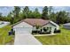 Charming single-story home with a well-manicured lawn, two-car garage and inviting front porch at 13486 English Sparrow Rd, Weeki Wachee, FL 34614