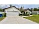 Charming house showing driveway, lawn, well-kept landscaping, and a two-car garage at 13486 English Sparrow Rd, Weeki Wachee, FL 34614