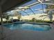 Inviting screened-in pool area featuring a well-maintained pool and peaceful backyard views at 1695 Stable Trl, Palm Harbor, FL 34685