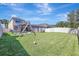 Expansive backyard with green lawn, a play structure, and screened pool enclosure at 17419 New Cross Cir, Lithia, FL 33547